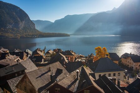 Autumn morning scenery of famous Hallstatt mountain village with lake and Alps mountains on backgroundの写真素材
