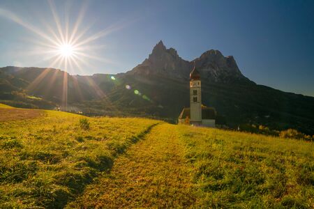 Traditional Tyrol church in the foothills of the Dolomites under autumn sun. South Tyrol, Italyの写真素材