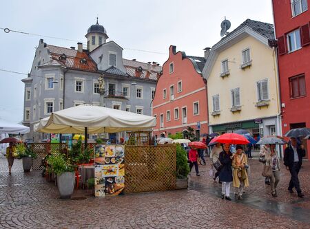 BRUNICO, ITALY - JULY 31, 2016: View of Brunico town promenade with its colorful houses and shops in the historic center of Brunico (Bruneck) during the rain, Alto Adige, Italyのeditorial素材