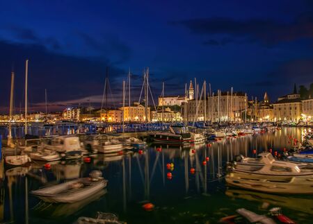 Night scape of harbour of Piran, Slovenia. Historic old buildings and St. George's Parish Church with italian campanile on the hill. Piran ia a popular sea resort on Adriatic coastの写真素材