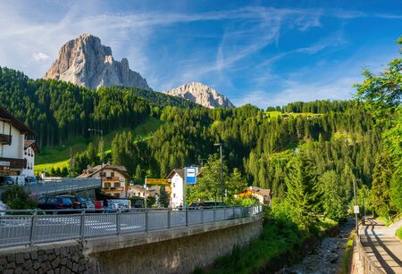 Santa Cristina Valgardena, Italy - August 3, 2016: Scenic view of the rapid river, green hills and rocky mountains from alpine village Santa Cristina. It is a famous resort in the Dolomites, Italyのeditorial素材