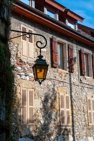 Retro yellow lantern on old worn wall background with shuttered windows, Annecy, Franceの写真素材