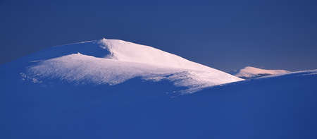 Minimalistic winter mountain landscape on sunset light.の写真素材