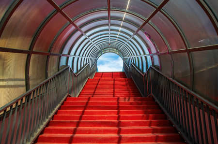 Red staircase with arched roof. Ascending forward to the sky. Modern architecture conceptの写真素材