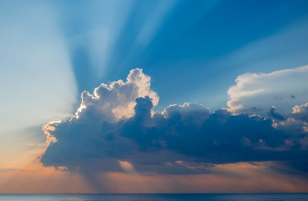 Magnificent sunset over sea. Sun covered by picturesque cloud with beautiful shine sun beams in sky. Abstract blue natural background, peaceful skyscape, open heaven and God, Adriatic seaの写真素材
