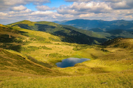 Scenic view of Apshynets glacial lake and Svydovets mountain range at sunny summer day. Amazing summer landscape of one of the popular travel destination in Ukrainain Carpathian Mountainsの写真素材