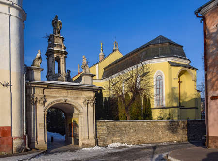 Ornate Triumphal Gate and Cathedral in Kamianets-Podilskyi, Ukraine at sunny winter day....