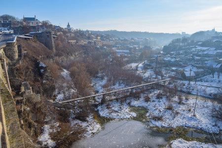 Scenic view of Smotrych canyon and Smotrych river in winter morning haze. Old city and Rus Filvarky Districts of Kamianets-Podilskyi, Ukraine. Fortified Rus Gate in the canyonの写真素材