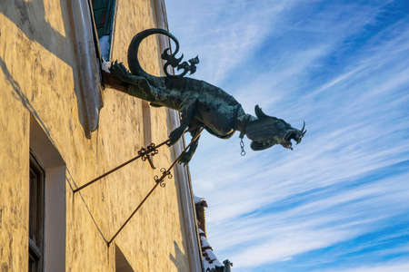 Dragon of Rus Magistrate (Town Hall) - stylized drainpipe against picturesque sky. Old city of Kamianets-Podilskyi, Ukraine at sunny winter dayの写真素材
