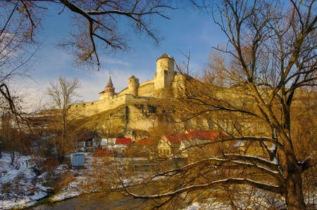 Scenic view of medieval fortress of Kamianets-Podilskyi, Ukraine from Smotrych Canyon through the branches of bare trees. Kamianets-Podilskyi is one of the most popular travel destination in Ukraineの写真素材