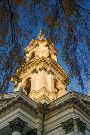 Bell tower of Holy Trinity Cathedral in Sumy, Ukraine illuminated with golden sunset light. Holy...