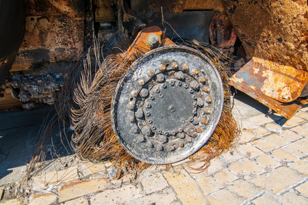 Burnt wheel of destroyed russian military armored car during Russian invasion of Ukraine in 2022. Rust tire cord and wheel hubのeditorial素材