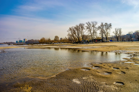 Scenic view of winding shoreline of Dnieper river, Cherkasy, Ukraine at early spring day. Bare treesの写真素材