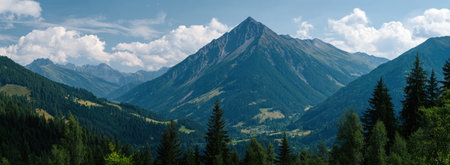 An expansive mountain landscape is visible with lush green trees in the foreground and a range of mountains under a partly cloudy blue sky. The image features a natural style, with varying shades of green and blue. This panoramic view could be suitable for various commercial and editorial applications.の素材