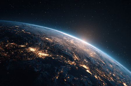 An aerial view showcases planet Earth from space, highlighting the curvature and atmosphere. City lights illuminate the land, contrasted by the dark void of space. The image features a sunrise casting a warm glow, with a serene and majestic composition. This could be used for educational materials, scientific articles, or commercial projects.の素材