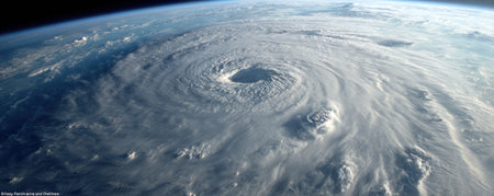 A detailed satellite image presents a large hurricane swirling over the ocean. The composition features white cloud formations and dark ocean waters. The image is likely captured from space, illustrating atmospheric phenomena. Suitable for various environmental or scientific topics and editorial applications.の素材