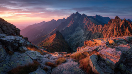 A stunning landscape showcases a mountain range under a colorful sky at dusk. The image displays rugged terrain and rock formations. The composition utilizes natural lighting to create shadows and highlights. This versatile image could be used for travel, nature, or environmental concepts in various commercial projects.の素材