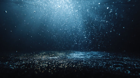 An underwater scene presents a dark blue environment filled with bubbles. Sunlight filters through the water, creating a spotlight effect. The composition suggests depth and tranquility, suitable for projects focused on nature, exploration, or abstract themes. This image may be used for various commercial and editorial purposes.の素材
