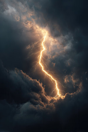 A striking image captures a powerful lightning bolt cutting through dense, dark clouds. The vivid yellow-orange electrical discharge contrasts with the ominous, textured gray and black cloud formations. The dramatic overhead shot evokes a feeling of awe. Suitable for various editorial and commercial projects.の素材