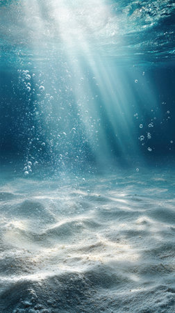 An underwater scene features sunbeams filtering through the water. Bubbles ascend from below, creating a sense of depth and movement. The textures include the sandy seabed, with the blue and white tones enhancing the underwater ambiance. Suitable for editorial and commercial use.の素材