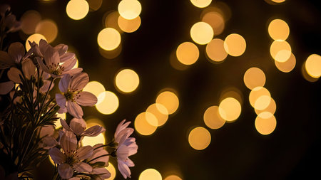 A close-up captures delicate flowers against a backdrop of soft, blurred lights. The image features a shallow depth of field, emphasizing the foreground flowers. Warm hues create a gentle atmosphere. This image is suitable for use in design, marketing materials, and other creative projects.の素材