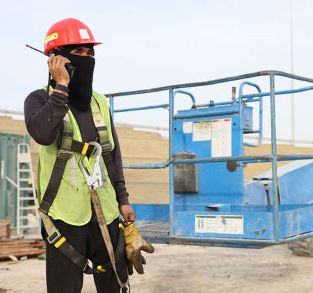 Construction Worker Wearing Protective Gear & Using A Handheld Transceiverの写真素材