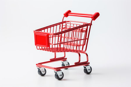 Red Shopping Cart. A bright red shopping cart stands prominently against a clean white background. The cart is empty, showcasing its sturdy metal construction and ergonomic design.の素材