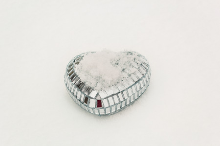 Shining decorative heart in the white snow in February dayの写真素材