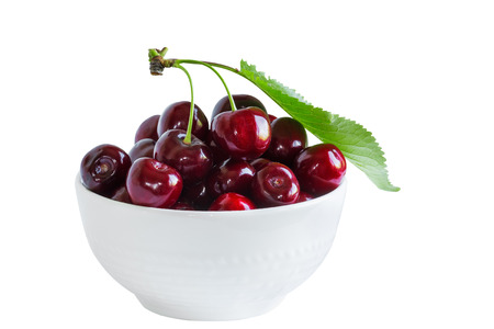 Ripe berries of sweet cherry in a white cup isolated on white backgroundの写真素材