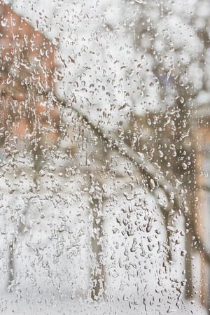 Texture of the ice and drops on the window glass in inclement winter weather, close upの写真素材