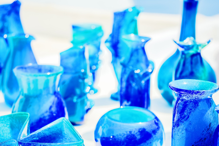 Blue glassware on a background of white stucco walls of the island of Santorini, Greece. Background blurred, selective focusの写真素材