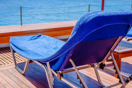Chaise-longue on the wooden deck over the sea on the Greek resort, close-upの写真素材