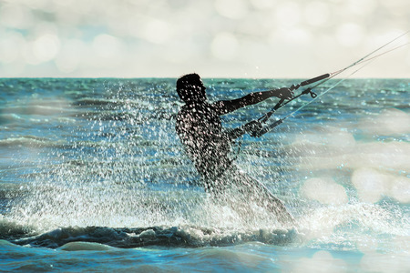 Surfer rushing through the sea in a spray cloud on the background of sunlight glare, close-upの写真素材