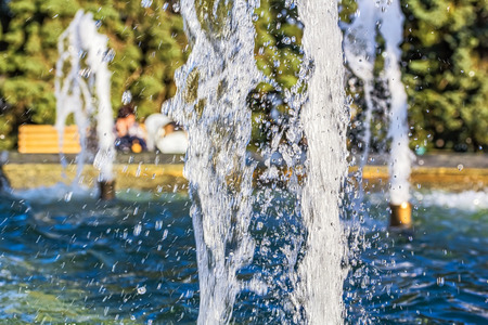 Jets of decorative fountain in the park at sunset in the backlight, close-up. Selective focusの写真素材