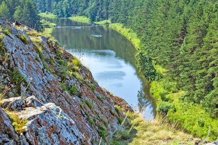 Scenic view from the cliff to the river with a suspension bridge and pine forest on a sunny summer...