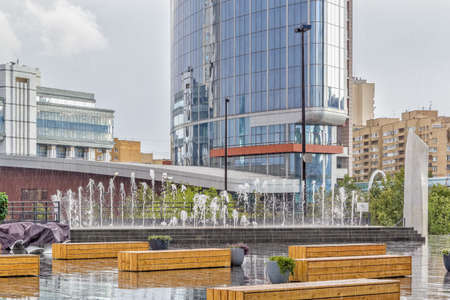 Terrace with fountain and wooden benches in the rain. Yekaterinburg city center, Russiaの写真素材