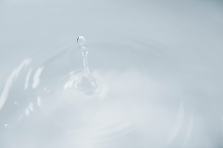 Water drop close-up. Splash effect after collision a falling drops with water Surfaceの写真素材