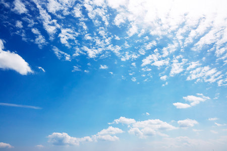 Blue sky background with tiny clouds. The vast blue sky and clouds sky on sunny day. White fluffy clouds in the blue sky.の写真素材