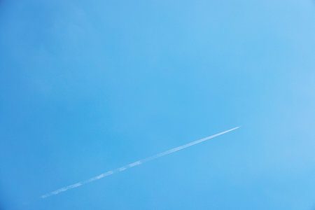Airplane trail in the blue sky with copy space for your textの写真素材