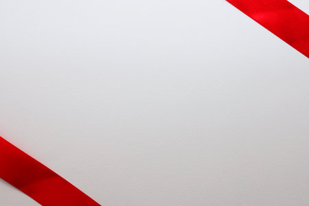 Red satin ribbon on a white background with copy space for textの写真素材