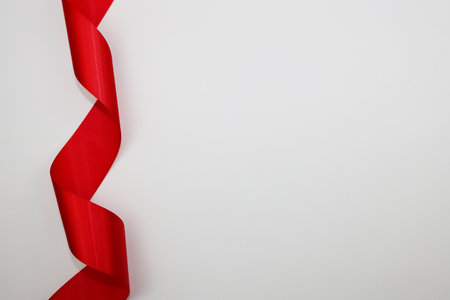 Curled red ribbon on white background with copy space for text.の写真素材