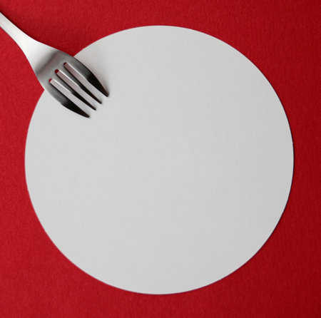 Empty card with fork on red background, top view, copy spaceの写真素材