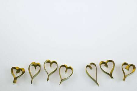 Heart shape made of gold ribbon on white background with copy space.の写真素材