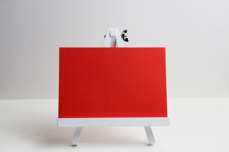White easel with red blank card on white background. Mock upの写真素材