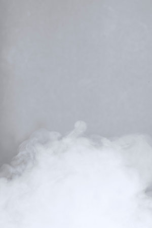 White smoke of steam on a gray background. Close-up.の写真素材