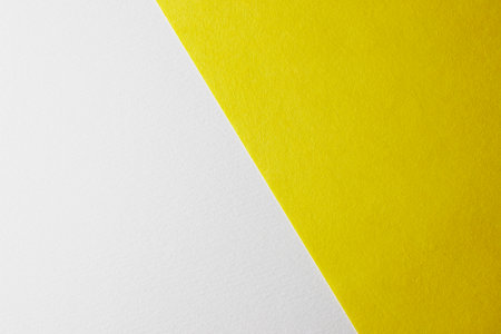 Yellow and white paper background. Minimalist design. Flat lay, top view.の写真素材