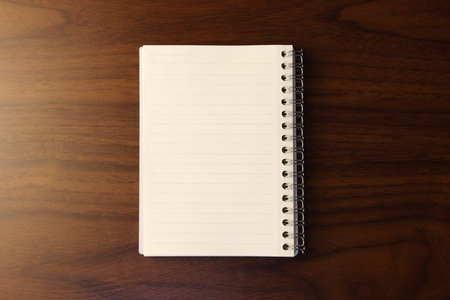 Notebook on the wooden table, top view, copy space.