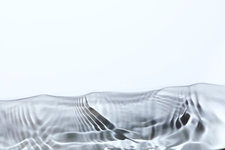 Water surface with ripples and waves on a white background close-upの写真素材