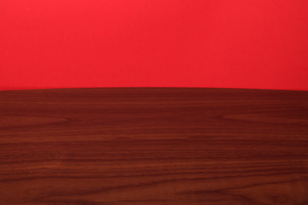 Wooden table top isolated on red background. Empty space for your design.の写真素材