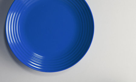 Blue plate on a white background. Top view. Flat lay.の写真素材